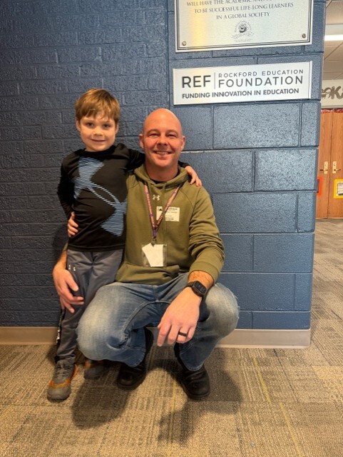 Picture of a smiling Dad in a green shirt with his student.